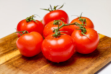 fresh tomatoes on a wooden chopping board
