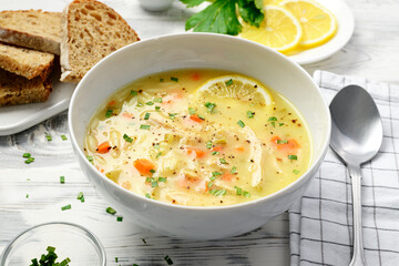 Fresh Prepared Lemon Chicken Orzo Soup. Healthy food. White wooden background.