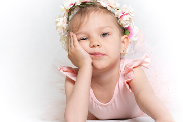 Studio portrait of a cute little girl with flower wreath looking bored