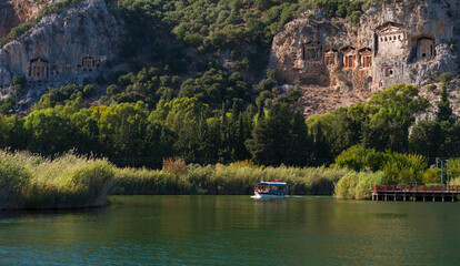 Lycian King Tombs in Kaunos Ancient City. Tourist boat on the Dalyan canal. Ortaca district, Mugla...