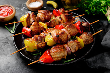 Kebabs - grilled meat skewers, shish kebab with vegetables on black  background.
