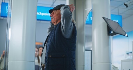 Airport Terminal: Diverse People Walking Through Metal Detector Scanner Gates. Security Officer Checks Passengers for Plane Flight Boarding Using Tablet Computer. Tourists Going on Holiday Trips.