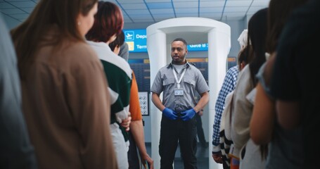 Airport Security Checkpoint: African American Security Officer Gives Instructions to Diverse...