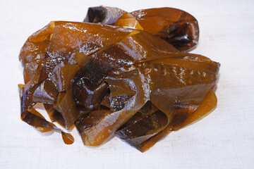 Fresh seaweed wakame on wood background. Japanese food.