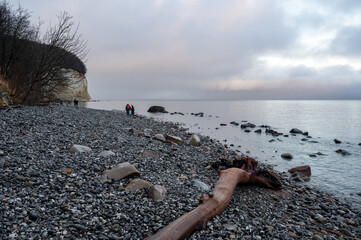 Chalk cliffs on the Baltic Sea on the island of Rügen on a cold winter day, with walkers on the beach