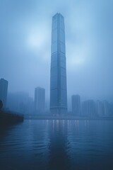 Modern skyscraper rising from the fog in urban landscape
