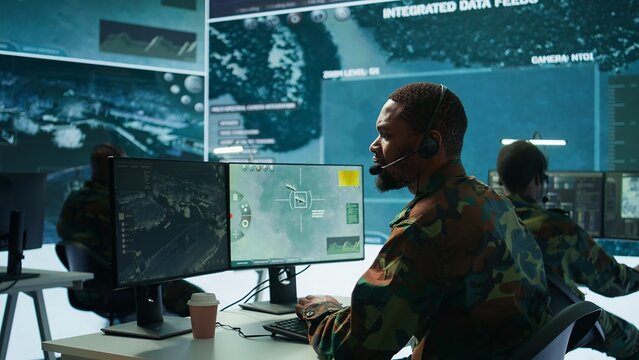 Soldiers in a state of the art military control room collaborate on data analysis, intelligence gathering, and mission planning. Ensure effectiveness and security of military operations. Camera B.