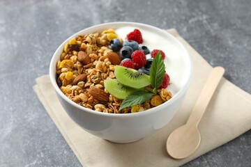 Delicious granola with berries and yogurt on a gray background