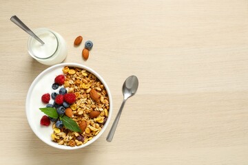 Delicious granola with berries and yogurt on a wooden background