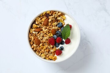 Delicious granola with berries and yogurt on a light background