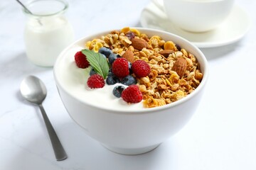 Delicious granola with berries and yogurt on a light background
