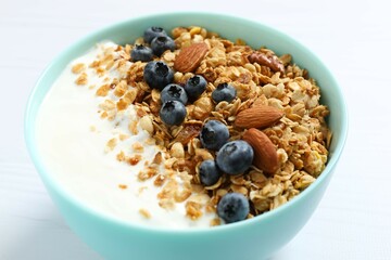 Delicious granola with berries and yogurt on a light background