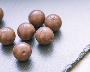 Schokoladengenuss im Frühling – dunkle Pralinen auf stilvollem Untergrund