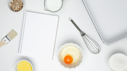 Baking ingredients for Crinkle Cake, including butter, milk, sugar, egg, nuts, open white notebook