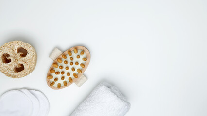 Eco-friendly self-care beauty tools routine, featuring a natural massage brush, reusable cotton pads, loofah sponge, a towel for mindful