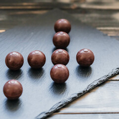 Schokoladenpralinen in sanftem Licht auf dunklem Schiefer