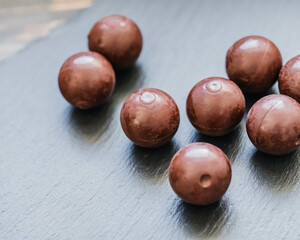 Schokoladenpralinen in sanftem Licht auf dunklem Schiefer