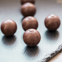 Zarte Schokokugeln in sanftem Licht und dunkler Umgebung
