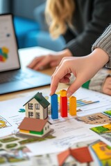 Real estate investment analysis with miniature house model and colored graphs on the table, showcasing property market trends and financial projections for investors.
