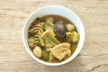 boiled pickled cabbage and bitter cucumber with tofu topping black mushroom in Chinese herb soup on bowl 