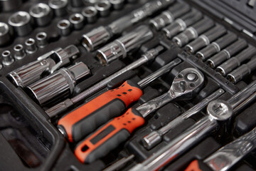 Fototapeta premium Closeup of tool box with kit of wrenches, screwdrivers and nuts for mechanic service