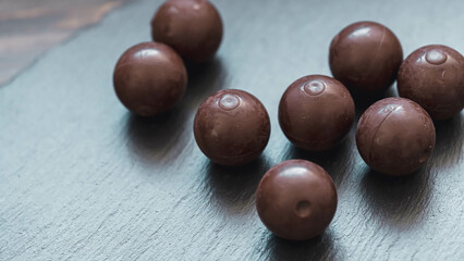 Schokoladenkugeln auf kühlem Schieferhintergrund