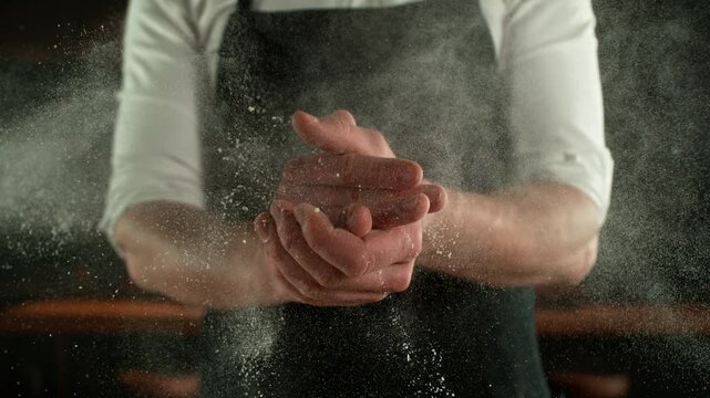 Super Slow Motion Chef Clapping Hands with Flour . Filmed on High Speed Cinema Camera, 1000 fps . Closeup of Bread or Pizza Dough Preparation