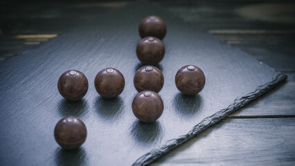 Stimmungsvolle Weihnachtsleckerei – dunkle Schokoladenpralinen auf Schiefer