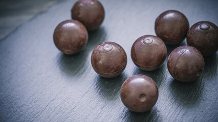 Stimmungsvolle Weihnachtsleckerei – dunkle Schokoladenpralinen auf Schiefer
