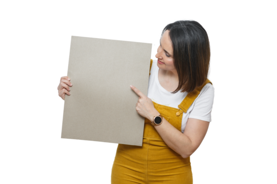 Smiling woman in yellow jumpsuit holding sign for text in bright setting