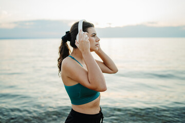 Young woman running or jogging on the beach at sunset	

