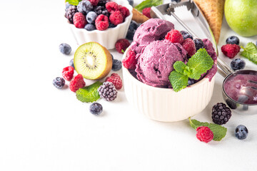 Homemade fruit and berry sorbet ice cream, portioned bowl with healthy fruit and berry yogurt gelato with fresh blueberry, raspberry, strawberry, blackberry, apples, kiwi on kitchen table
