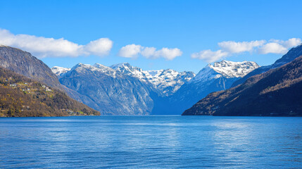 Obraz premium Breathtaking Norwegian fjords with sharp mountain peaks rising from deep blue waters under a clear sky
