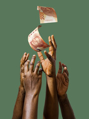 Many black African hands reaching out for South African rand notes money over green background....