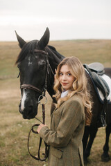 Fototapeta premium Woman Posing With Black Horse in an Open Field Setting