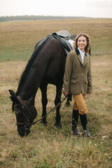 Young Woman Standing with Her Horse in a Scenic Field Outdoors