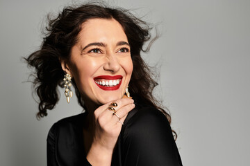 Brilliant smile of a young woman dressed elegantly in a stylish studio setting