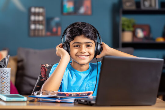 indian schoolboy studying on laptop
