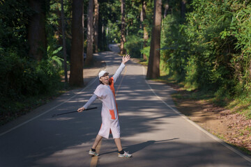 Asian woman relax beautiful rural road with rubber trees along the curve way is a famous place and...