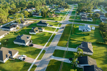 Aerial view of american small town in Florida with private homes between green palm trees and...