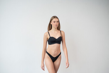 Fototapeta premium Casting snapshot of a fresh-faced model in simple black underwear, highlighting her natural features, body proportions, and confident stance. Ideal for agency scouting and professional portfolio updat