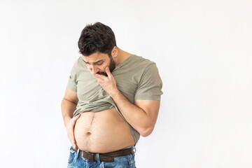 Shocked man clutches his swollen belly