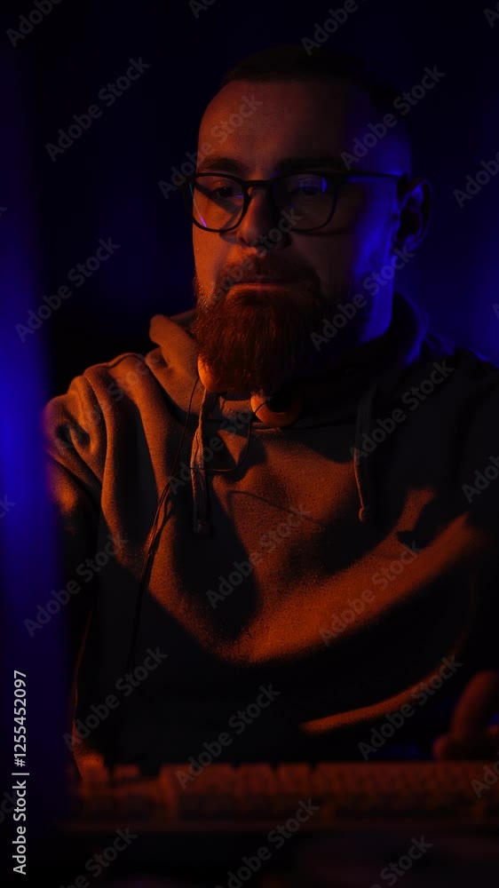Poster vertical view of cyber security expert from 1990's working on computer in dark room