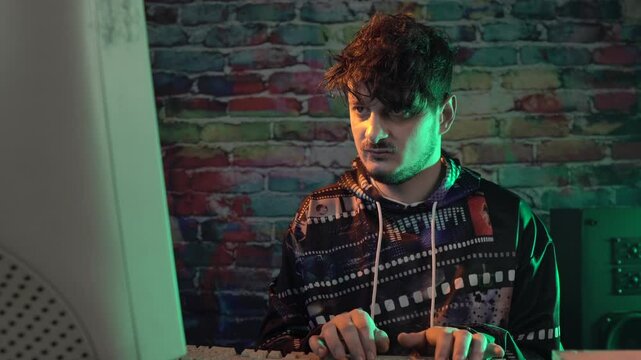 Computer Geek Working on Desktop PC From 1980's. Typing on Keyboard and Looking at Screen