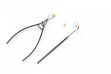 Dental teeth crowns and steel instruments for dental prosthetics, top view. Dentist desk, white...