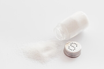 Fine salt in salt shaker and spilled salt. Cooking concept