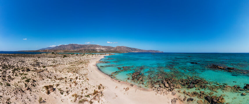 Aerial view of Elafonissi Beach in Southwest Crete, Greece with turquoise waters and a sandy coastline.