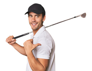 Young Hispanic man with golf club points with thumb finger away, laughing and carefree.