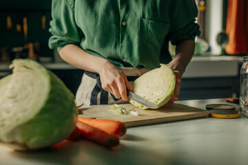 Person preparing cabbage for sauerkraut in a home kitchen