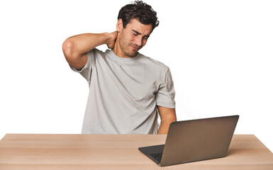 Hispanic young man working on laptop suffering neck pain due to sedentary lifestyle.